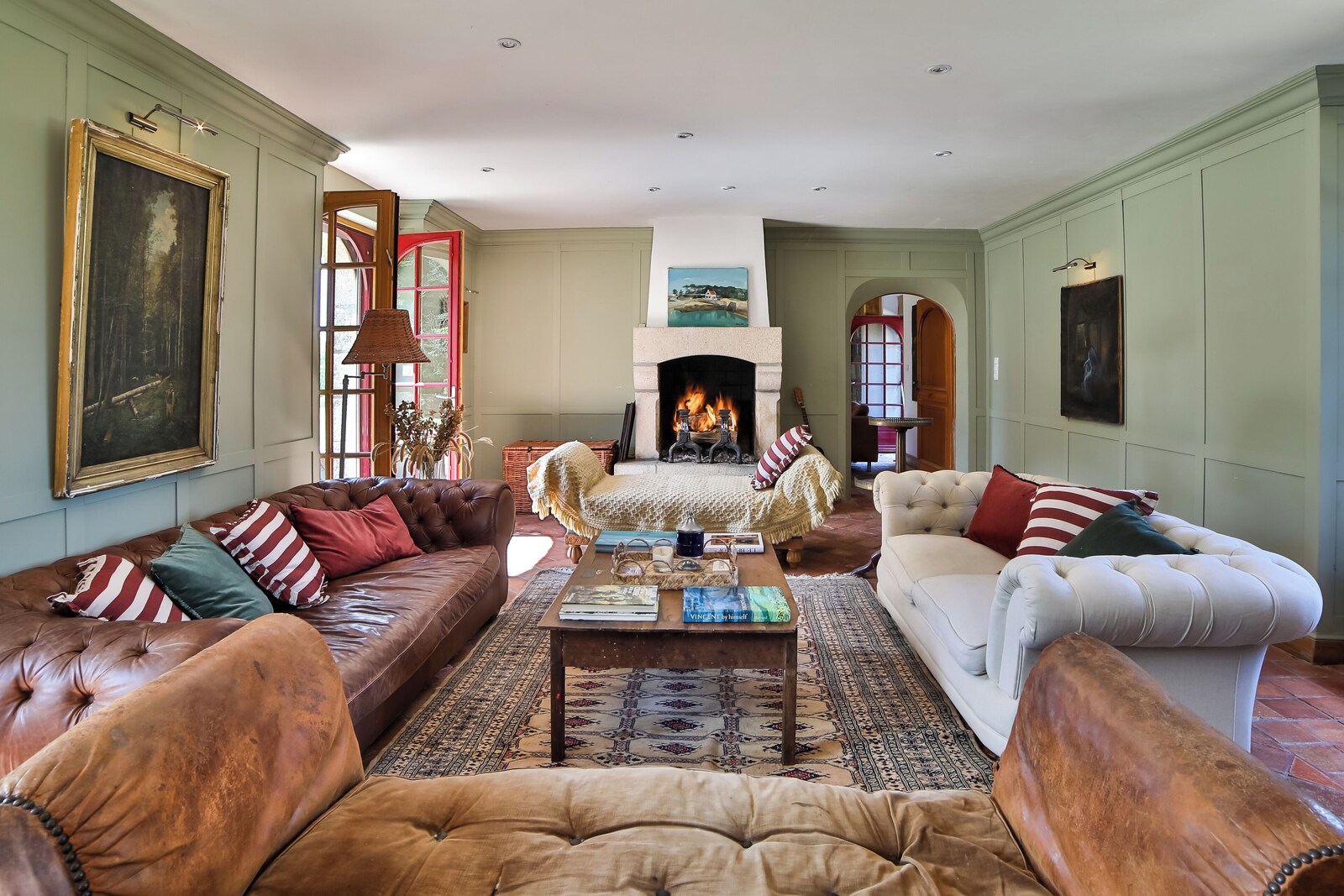 The spacious sitting room at Le Cholo, with leather sofas and an open fire